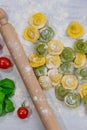 Homemade fresh Italian ravioli pasta on white wood table with flour, basil, tomatoes,background,top view Royalty Free Stock Photo