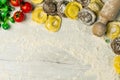 Homemade fresh Italian ravioli pasta on white wood table with flour, basil, tomatoes,background,top view Royalty Free Stock Photo