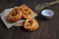 Homemade pretzels, salt and ears of wheat on a dark wooden table