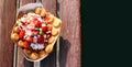 Homemade freshly baked belgian waffles with ice cream and fruites on wooden table. Royalty Free Stock Photo