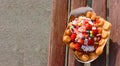 Homemade freshly baked belgian waffles with ice cream and fruites on wooden table. Royalty Free Stock Photo