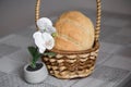 Homemade freshly baked bread is in a basket on the table. There are Orchid flowers next to it Royalty Free Stock Photo
