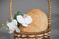 Homemade freshly baked bread is in a basket on the table. There are Orchid flowers next to it Royalty Free Stock Photo