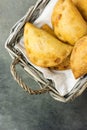 Homemade freshly baked Empanadas Turnover Pies with pisto vegetable cheese filling in tomato sauce in wicker basket.