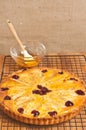 homemade, freshly baked pear cranberry tart with almonds cooling on a wire cooling rack