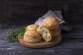 Homemade freshly baked scones with cheese and herbs on wooden board on wooden table