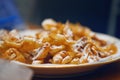 Homemade fried cookies made from thin twisted dough, dusted with powdered sugar on a plate Royalty Free Stock Photo