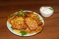 Homemade fried potato pancakes with sour cream on wooden table Royalty Free Stock Photo