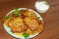 Homemade fried potato pancakes with sour cream on wooden table Royalty Free Stock Photo