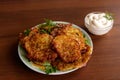 Homemade fried potato pancakes with sour cream on wooden table Royalty Free Stock Photo