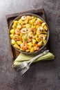 Homemade fried potatoes with garlic, herbs and shrimp close-up in a plate. Vertical top view Royalty Free Stock Photo