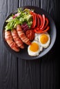 Homemade fried sausages wrapped in bacon, eggs, sauce and fresh Royalty Free Stock Photo
