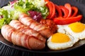 Homemade fried sausages wrapped in bacon, eggs, sauce and fresh Royalty Free Stock Photo