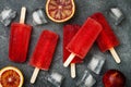 Homemade frozen blood orange natural juice alcoholic popsicles - paletas - ice pops. Overhead, flat lay, top view.