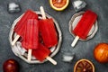 Homemade frozen blood orange natural juice alcoholic popsicles - paletas - ice pops. Overhead, flat lay, top view.