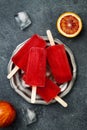 Homemade frozen blood orange natural juice alcoholic popsicles - paletas - ice pops. Overhead, flat lay, top view.