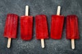 Homemade frozen blood orange natural juice alcoholic popsicles - paletas - ice pops. Overhead, flat lay, top view.