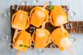 Homemade frozen ice cream popsicles made with oragnic fresh oranges on wooden background Royalty Free Stock Photo