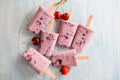 Homemade frozen ice cream popsicles from yogurt and blackcurrant on wooden background