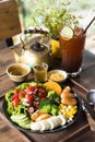 Homemade fruit vegetable salad, honey mustard, tomato,strawberry,orange,apple,banana,maize and sausage in bowl  with lemon tea on Royalty Free Stock Photo