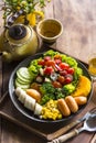 Homemade fruit vegetable salad, honey mustard, tomato,strawberry,orange,apple,banana,maize and sausage in bowl  with lemon tea on Royalty Free Stock Photo