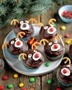 Homemade funny cupcakes Santa`s reindeers on a wooden background. Christmas idea for kids.