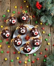 Homemade funny cupcakes Santa`s reindeers on a wooden background. Christmas idea for kids.