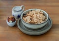 Homemade Gadola, Cereal and Nuts in Ceramic bowl served with Almond milk on wooden table