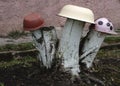Homemade garden sculpture - mushroom amanita on the grass. The mushroom is made from an old plate and log. Upcycling. Royalty Free Stock Photo
