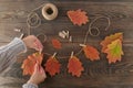 Homemade garland of colored autumn leaves with womans hands