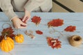 Homemade garland of colored autumn leaves with womans hands