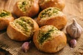 Homemade garlic bread rolls on wooden background.