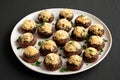Homemade Garlic Parmesan-Stuffed Mushrooms on a plate on a black background, side view Royalty Free Stock Photo