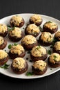 Homemade Garlic Parmesan-Stuffed Mushrooms on a plate on a black background, side view Royalty Free Stock Photo