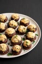 Homemade Garlic Parmesan-Stuffed Mushrooms on a plate on a black background, side view Royalty Free Stock Photo