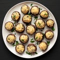 Homemade Garlic Parmesan-Stuffed Mushrooms on a plate on a black background, top view Royalty Free Stock Photo
