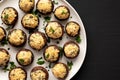 Homemade Garlic Parmesan-Stuffed Mushrooms on a plate on a black background, top view. Copy space Royalty Free Stock Photo
