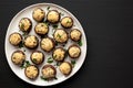 Homemade Garlic Parmesan-Stuffed Mushrooms on a plate on a black background, top view. Space for text Royalty Free Stock Photo