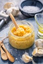 Homemade garlic paste in a jar with peeled garlic, salt, crusher and garlic heads