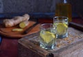 Homemade ginger tincture or ale on wooden background. Rustic style. Spice yellow liqueur in a glass. Alcohol drink. Royalty Free Stock Photo