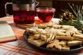 Homemade gingerbread cookies on a plate, on the background of a teapot with hibiscus tea and pine tree branch and cone. Royalty Free Stock Photo