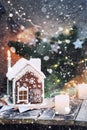 Homemade gingerbread house with candles, christmas lights and artificial falling snow Royalty Free Stock Photo
