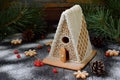 Homemade gingerbread house with pine branches, cones and biscuits on dark background. European Christmas traditions. Xmas holiday Royalty Free Stock Photo