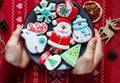 Homemade gingerbreads on plate on wooden background. Holidays and celebration concept, greeting card mockup, festive decoration