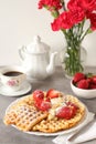 Homemade golden brown waffle topped with strawberries, nuts and whipped cream Royalty Free Stock Photo