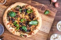 A homemade gourmet mushroom and shallots pizza ready for sharing.
