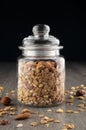Homemade granola in jar on kitchen table, healthy breakfast of oatmeal muesli, nuts, seeds and dried fruit. Royalty Free Stock Photo