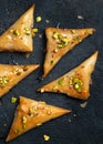 Homemade Greek feta cheese Phyllo Triangles pies with honey and pistachios. Cooking sweets turkish, or arabic traditional ramadan