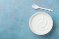 Homemade greek yogurt in bowl on blue stone table top view.