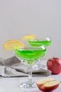 Homemade green apple martini cocktail with apple pieces in glasses vertical view Royalty Free Stock Photo